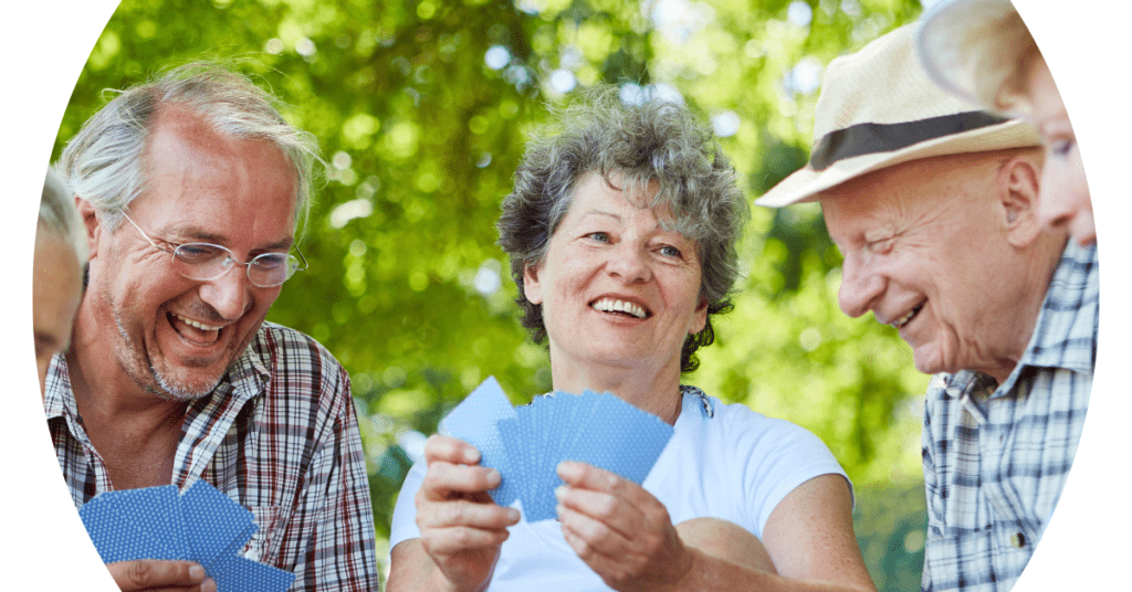 2 older men and a woman playing cards